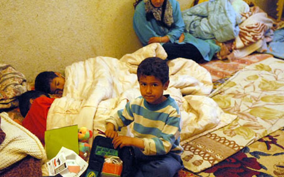 A young Iraqi boy opens a gift he received from American on patrol through his neighbor in Hawijah on Feb. 27.