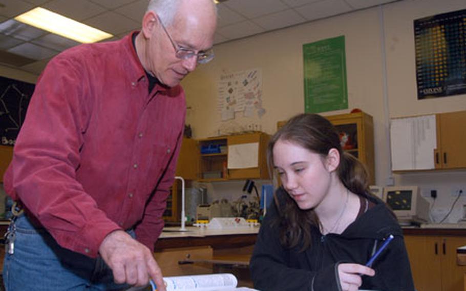 Garrett Billington, an earth science teacher at Lakenheath High School, assists ninth-grader Renee Anderegg in her studies.