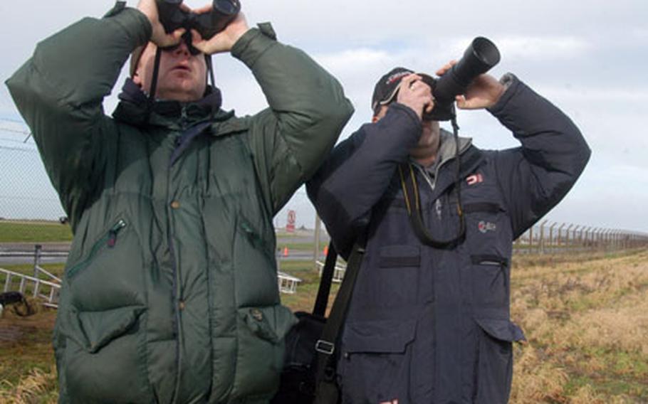 Chris Clarke, left, and Dave Simmons, both from England&#39;s Midlands region, watch the skies above RAF Mildenhall for incoming aircraft. A group of about 10 aircraft enthusiasts, known as tail spotters, were waiting for the departure of a Navy P3-C Orion aircraft that was being refueled on the base Feb. 28.