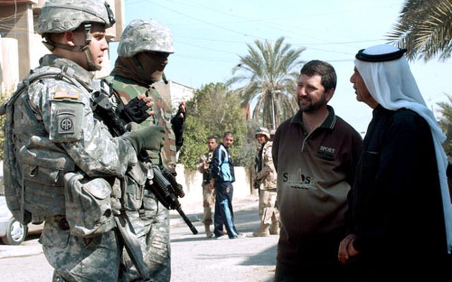 Capt. Jeff Noll of Fairfax, Va., a fire support officer with 1st Battalion, 23rd Infantry Regiment, speaks with Iraqis in Sadr City on Sunday. U.S. and Iraqi troops are now opening a Joint Security Station in the notorious Baghdad neighborhood.