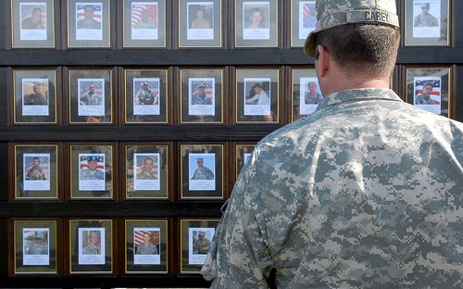 following the welcome home ceremony for the 1st Brigade Combat Team at the parade field on Ray Barracks in Friedberg, Germany, Sgt. 1st Class David Carey of 1st Battalion, 37th Armor Regiment, looks at one of the memorial boards depicting the 1st BCT&#39;s fallen soldiers.