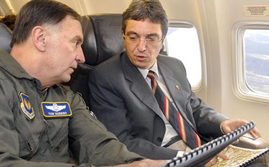 Gen. Tom Hobbins, commander of U. S. Air Forces in Europe, and Roger Lewentz, of the Ministry of the Interior of Rheinland-Pfalz, talk about flying procedures out of Ramstein Air Base, Germany, during a distinguished-visitor flight Tuesday.