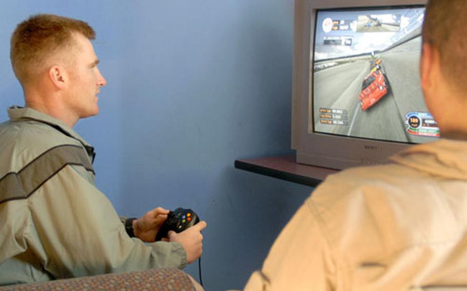 Cpl. John Heathcoat, 29, a 1st Cavalry Division soldier from Orlando, Fla., plays an Xbox NASCAR game as Lance Cpl. Erich Rankin, 21, a Company E, 2nd Battalion, 7th Marine Regiment Marine from Round Rock, Texas, looks on Monday at Kleber Kaserne in Kaiserslautern, Germany. The 21st Theater Support Command’s Military Training Detachment runs a 330-bed facility for Landstuhl Regional Medical Center outpatients to live in when they are not at medical appointments.