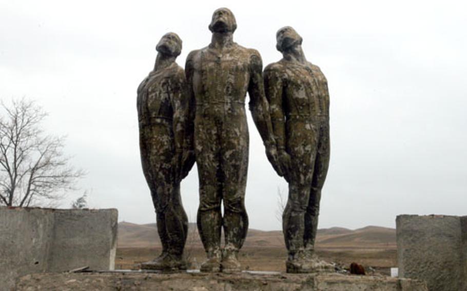 A monument to what appears to be pilots or cosmonauts standing with their backs arched, hands pointed behind them, looking to the skies at Krtsanisi Training Area, Georgia.