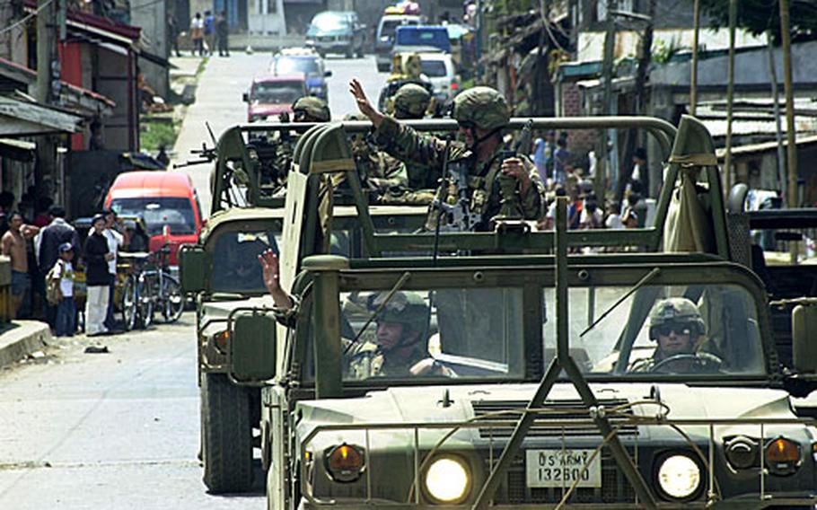 Troops with the Joint Special Operations Task Force-Philippines wave to Jolo Island residents during a recent convoy.