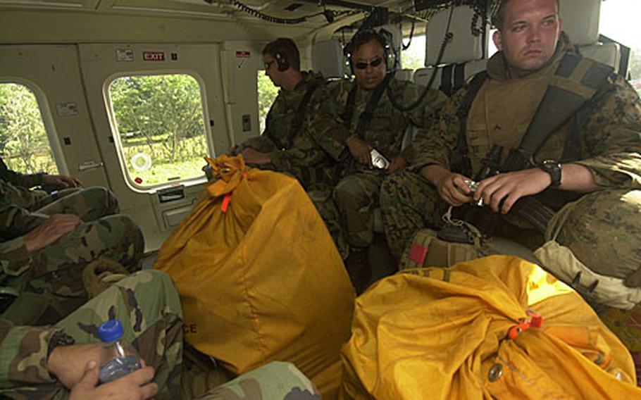 Joint Special Operations Task Force-Philippines troops load into a helicopter along with bags of mail on a trip from Advance Operating Base-920 on Jolo Island to an outlying "team house."