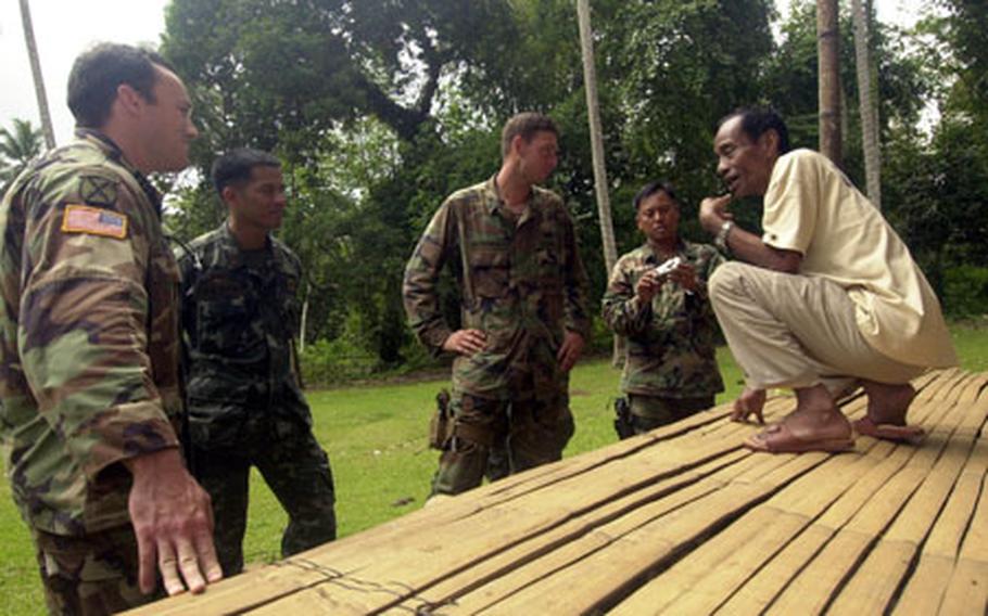 U.S. and Filipino personnel discuss planned renovations to a Jolo Island school that sits on one of the main routes local insurgents use to access the Jolo Island coast. U.S. officials hope that the project will encourage local residents to report insurgent activity.