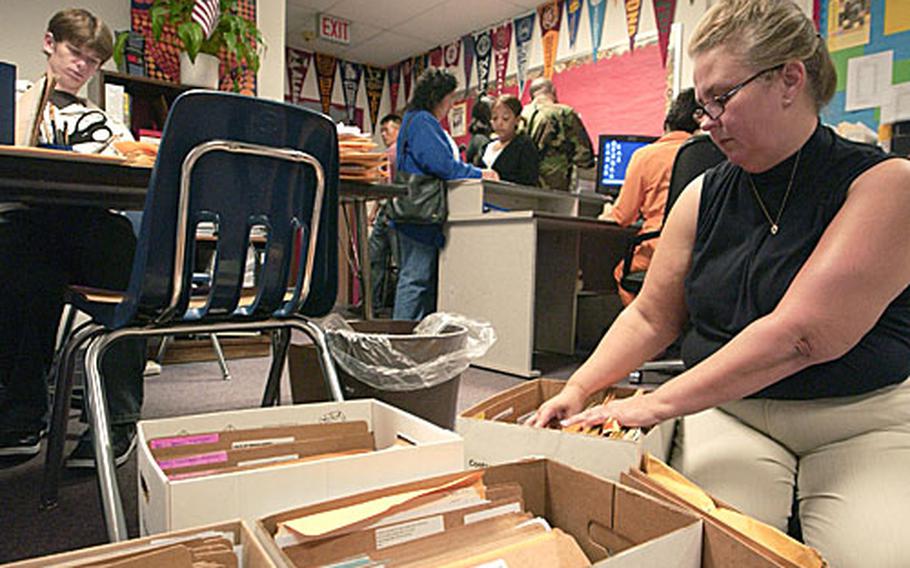 Gretchen Tucker, a volunteer at Ramstein High School in Germany, helps students with their class schedules and enrollment last August. Many Ramstein High students will be moved to nearby Kaiserslautern High School due to overcrowding.