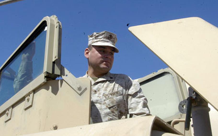 Cpl. Michael Florez, of Company F, 2nd Battalion, 5th Marines, inspects the turret of a Humvee modified to feature a ballistic glass shield.