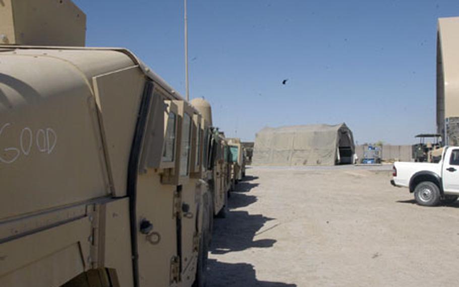 Several Humvees are lined up outside the maintenance tent at Camp Taqaddum, in western Iraq, waiting to be retrofitted with ballistic glass shielding around the turret.