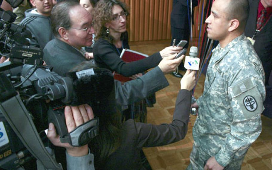 Spc. Angel Regalado-Contreras, 26, a native of Mecico serving with the U.S. Army&#39;s 6th Infantry, 1st Armored Division at Baumholder, Germany, talks to reporters after his naturalization ceremony.