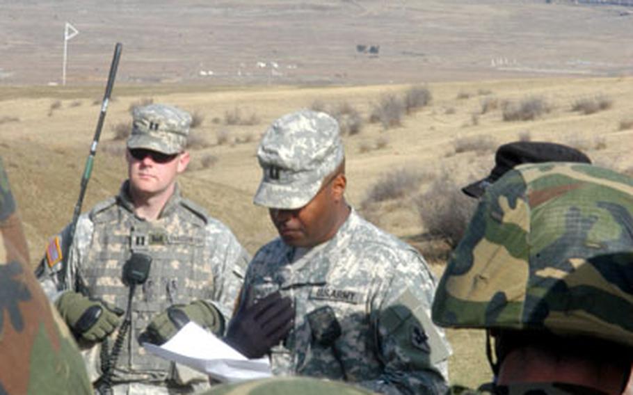 U.S. Army Capt. Marlon Ringo, center, briefs future Georgian army engineers on C4 detonation.
