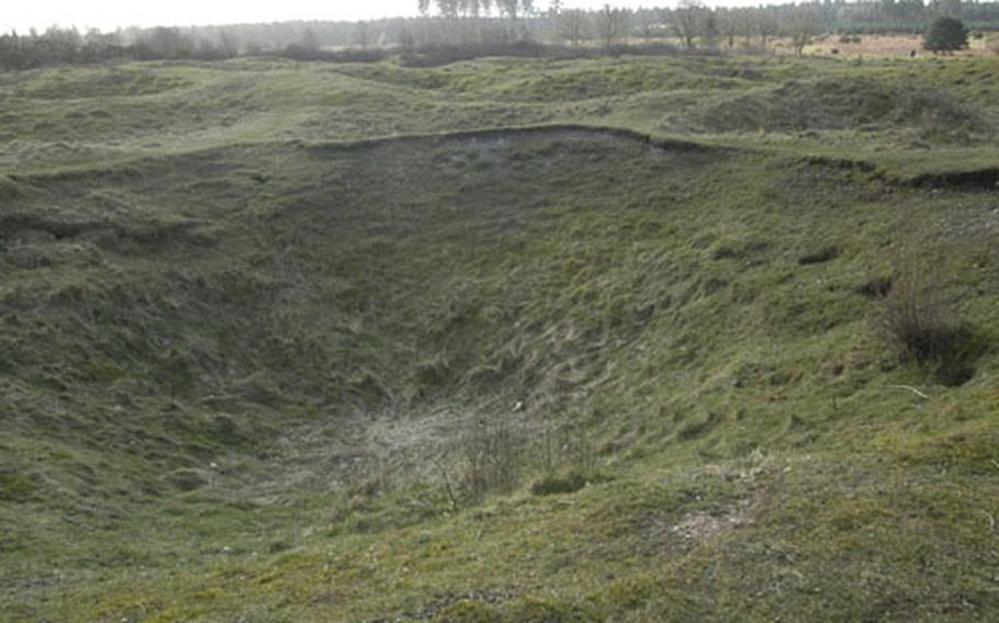Some of the Neolithic flint mines at Grimes Graves. The shafts, some as deep as 30 feet or more, were filled in each year with the dirt and chalk dug out of new mines.