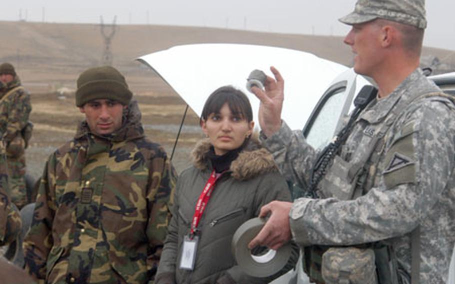 For interpreters like Keti Maghalashvili, center, working as an translator between American instructors and Georgian army soldiers means long hours, sometimes-nasty weather, and double what many professional jobs pay in the nearby capital of Tblisi. On a recent day, she helped Army Sgt. Scott Bell explain what to look for when searching a vehicle for bombs at checkpoints.