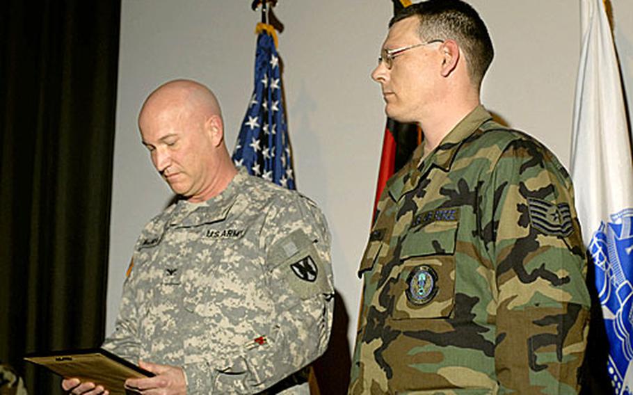Col. Michael MacNeil, the commander of the 37th Transportation Command, prepares to award the Army combat action badge to Tech Sgt. Daniell Stanton, a vehicle operator from the 435th Vehicle Readiness Squadron, for his actions as a convoy commander during his deployment to Iraq Wednesday at Ramstein Air Base. During one of his convoys, Stanton came under enemy fire but did not sustain any injuries or damage to his vehicles. The Air Force does not have an equivalent medal for serving in combat.