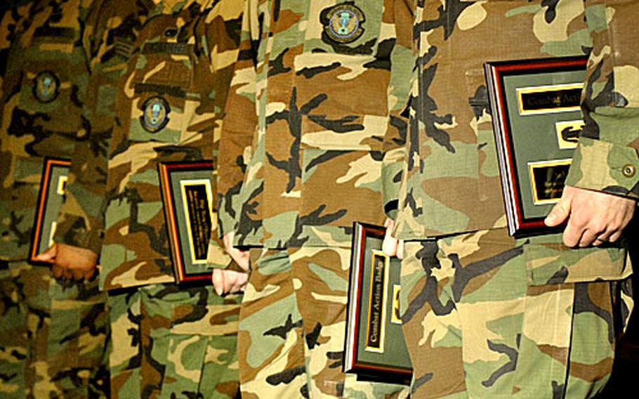 U.S. Air Force vehicle operators from the 435th Vehicle Readiness Squadron hold their Army combat action badges that they received during a ceremony Wednesday at Ramstein Air Base, Germany. Col. Michael MacNeil, the commander of the 37th Transportation Command, awarded the airmen the Army combat action badge for coming under enemy fire during a convoy mission.