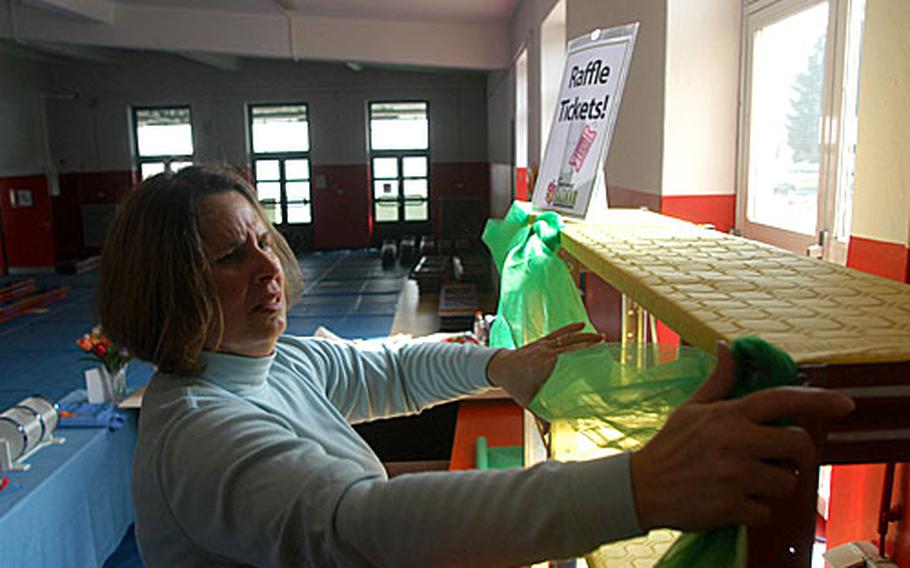 Lu Jean Whitten on Wednesday hangs decorative netting on shelves that will contain raffle items at the Stuttgart Community Spouses Club Spring Bazaar, to be held Friday through Sunday at Patch Barracks in Stuttgart, Germany.