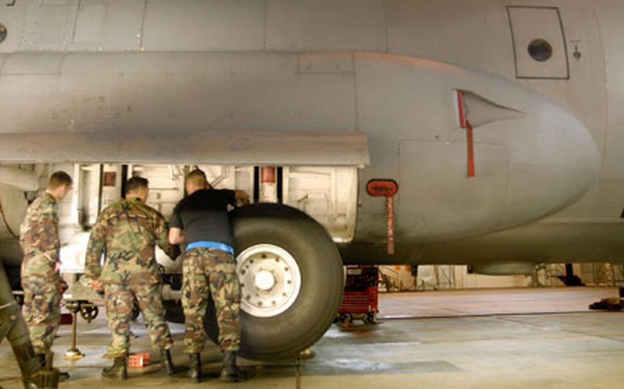 Airmen from the 86th Aircraft Maintenance Squadron examine the rear landing gear of a C-130 scheduled for structural repair Thursday at Ramstein Air Base, Germany.