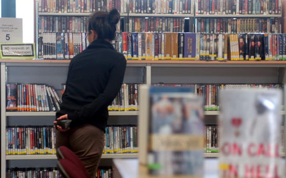 A patron of the Patrick Henry Village library looks through the DVD collection, where cinephiles can find an eclectic collection including classics like "The Red Shoes," 1960s comedies with Doris Day and Rock Hudson, and miniseries from the British Broadcasting Company.