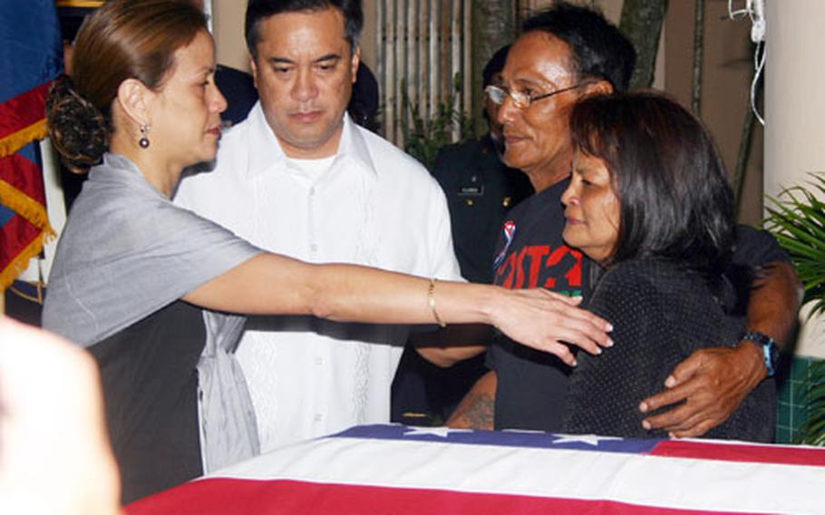 Joanne Camacho, wife of Governor Felix Camacho, reaches out to comfort Joseph and Marie Fernandez, parents of deceased Guam Army National Guardsman Sgt. Christopher Fernandez.