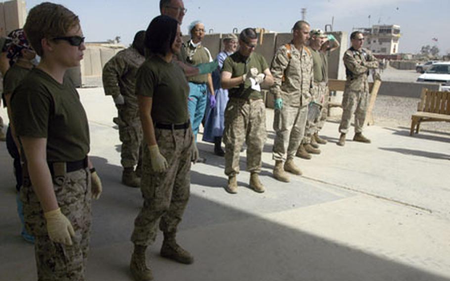 Medical personnel from the surgical unit at Camp Taqaddum anxiously wait for a helicopter to land and bring in Iraqi patients who had been injured in a car accident.
