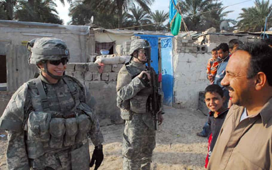Sgt. Brandon Daggs, 23, of Oakland, Calif., left and Pfc. Josh Pedersen, 21, of Detroit, right, interact with residents recently in the eastern Baghdad neighborhood of Zafaraniyah.