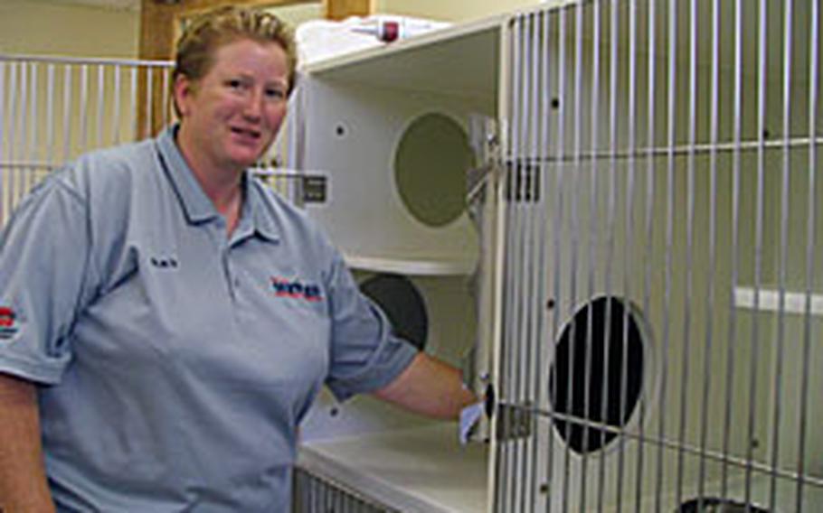Tracy Perez, animal health care manager for Karing Kennels on Kadena Air Base, displays one of the new cat condos. Karing Kennels&#39; new 8,800 square-foot center is almost four times the size of the old facility.