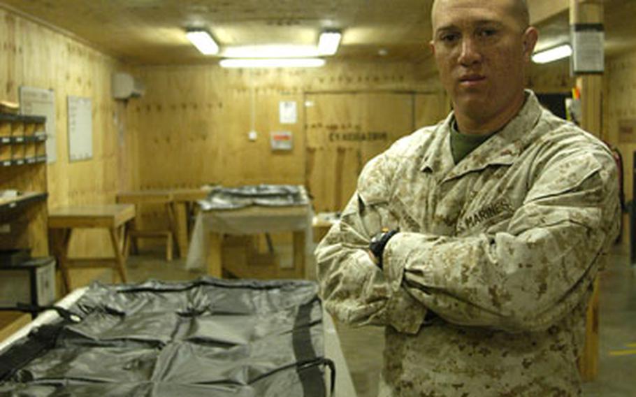 Chief Warrant Officer 2 Brad Harris, officer in charge of the Personnel Retrieval and Processing Company (Forward), a new name for Mortuary Affairs, stands in the room where his Marines process the bodies of troops who die in western Iraq.