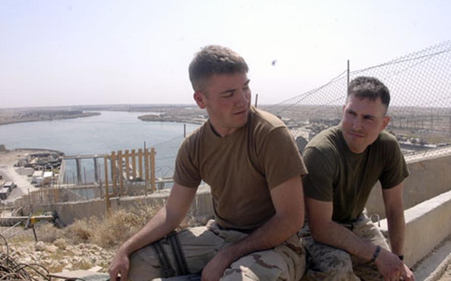 Navy Fireman Apprentice Jeff Theissing, left, and Marine Corps Pvt. Brandon Quinnelly take a smoke break Wednesday on Haditha dam. Theissing is one of 230 sailors who will make up Riverine Squadron One, the first of the Navy’s “brown water” forces in three-decades. Quinnelly, with Company F, 2nd Battalion, 3rd Marines, is on his way home in several weeks after a seven-month deployment to provide security at the dam.