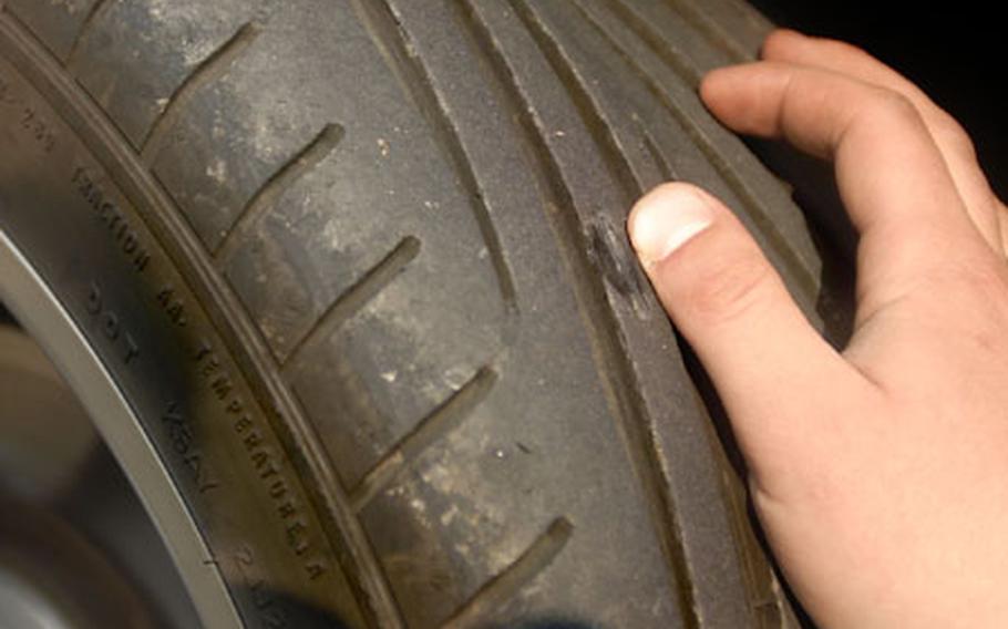 Spc. Derrik Mullin from the 5th Maintenance Company shows the tire damage (to the left of his thumb) he said he sustained by driving over the tire shredders at Rhine Ordnance Barracks in Kaiserslautern, Germany. The shredders, designed as a force protection device, have become common on military installations overseas.