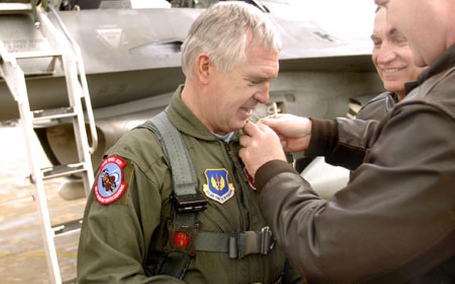 Lt. Col. Matt “Nuttman” Chesnutt, the commander of the 22nd Fighter Squadron, pins an F-16 pin on Gen. Col. Aleksandr Zelin, the deputy commander and chief of the Russian Air Force, after receiving a flight in an F-16D “Block 50” fighter aircraft Wednesday at Spangdahlem Air Base.