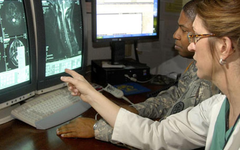 Dr. Alisa D. Gean, a neuroradiologist and traumatic brain injury expert, along with Army Lt. Col. (Dr.) Ricanthony Ashley, chief of radiology at Landstuhl Regional Medical Center, discuss traumatic brain injuries on a computed tomography scan, also know as a CT Scan on Tuesday at LRMC. Gean, a TBI expert, volunteered to spend time at LRMC helping doctors and teaching.