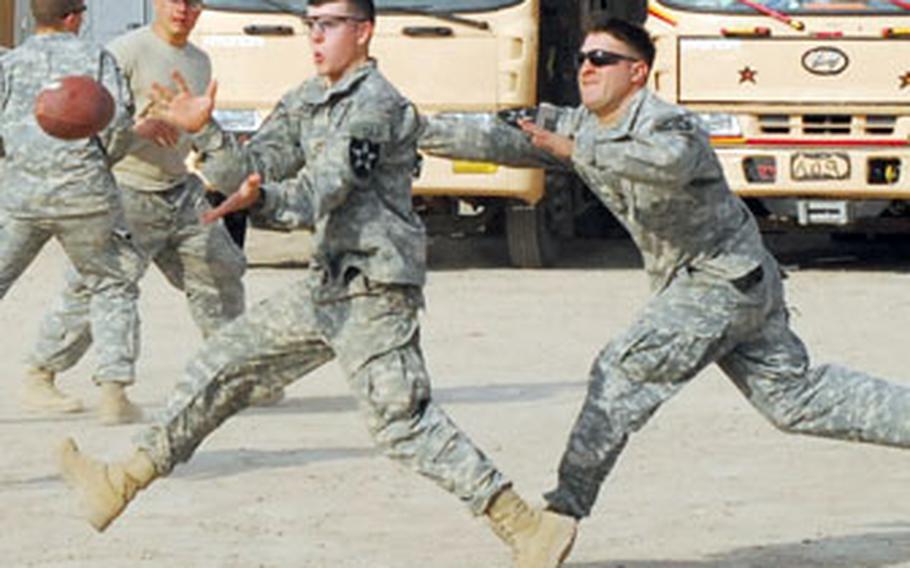 Soldiers with 1st Platoon, Battery B, 2nd Battalion, 17th Field Artillery Regiment, play touch football while on call for quick reaction force duty at the Zafaraniyah Government Center in east Baghdad recently.