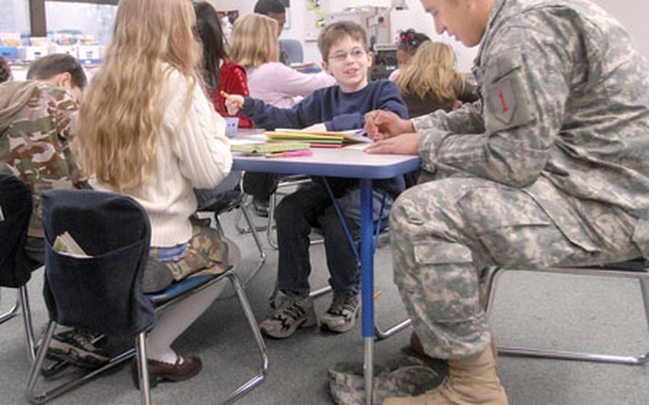Sgt. Nicolas Moreno, a soldier from the 1st Engineering Battalion, works on a craft with Benjamin Pendergast and Marissa Engleman on Thursday at Ramstein Elementary School.