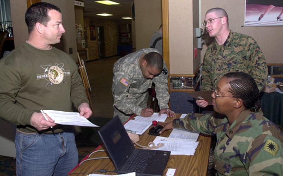 From left, Capt. Robert James and Sgt. Jorge Rivera complete in-processing forms with guidance from Marine Cpl. Raymond Cate and Army Sgt. Jannette McCoy at the Camp Henry Joint Reception Center in Daegu, South Korea, on Saturday. Reception centers at Yongsan Garrison, Osan Air Base, Camp Henry and Chinhae Naval Base are welcoming about 6,000 servicemembers during the Reception, Staging, Onward movement and Integration exercise happening all over South Korea.