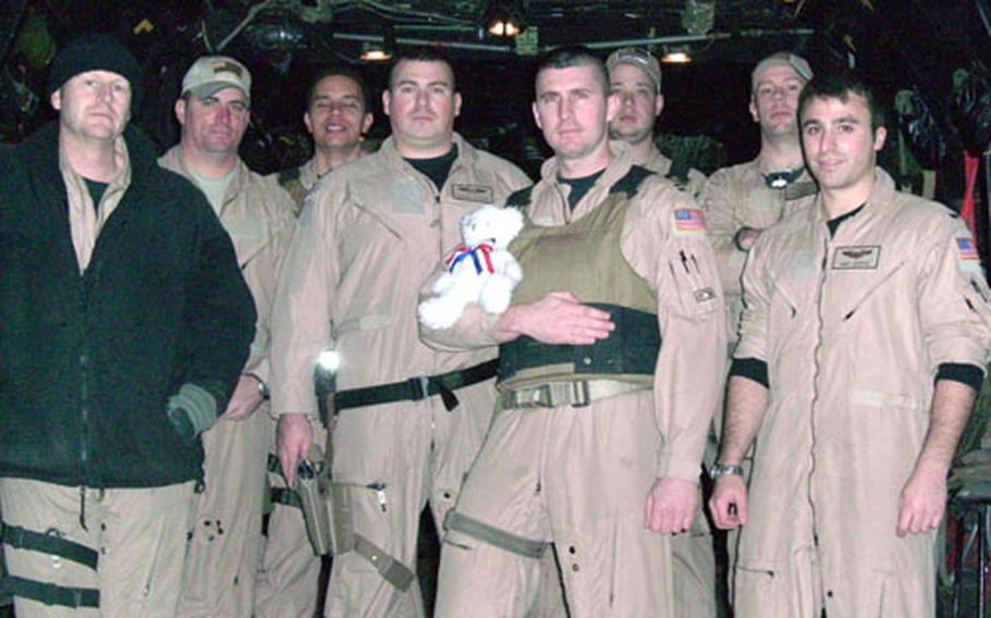 The aircrew of Kadena Air Base, Okinawa&#39;s 17th Special Operations Squadron, with whom E.C. Killin Elementary School students corresponded, pose in Iraq with a stuffed bear sent to them by the students.
