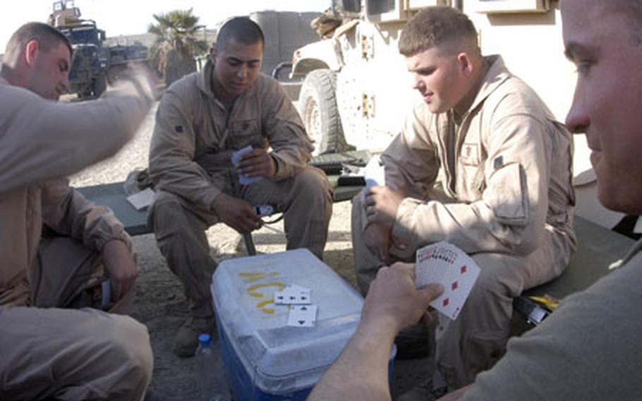 Marines with 3rd Platoon, Transportation Support Company, Combat Logistics Battalion 2, play a game of “spades” during a break Wednesday afternoon as contractors off-load and re-load supplies.
