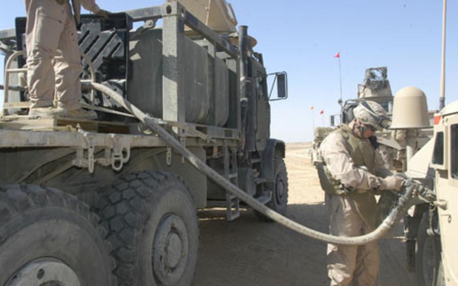 A Marine with Security Company, Combat Logistics Battalion 2, refuels a Humvee at a small camp near al Asad Air Base. Security Company Marines drive between 700 and 800 miles during each 72-hour patrol on key roadways, scanning for roadside bombs or those who might try to plant them.