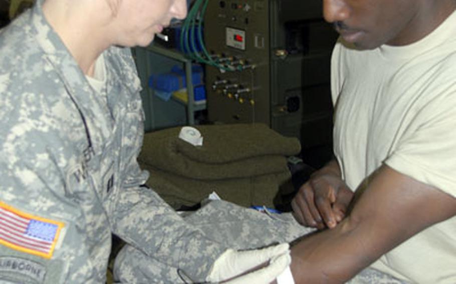 Capt. Kevan Weaver, head nurse of the 212th Combat Support Hospital&#39;s emergency medical treatment room, gives intravenous fluids to Sgt. Shawn Sullivan, 28, of Jacksonville, Fla. on Monday.