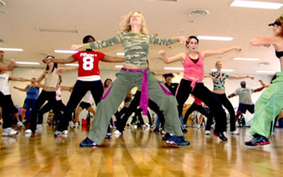 Master Zumba instructors Jani Roberts (front left) and Rebecca Lee, with back to camera, lead a class of MWR fitness instructors through an aerobic dance routine last week at Yokosuka Naval Base, Japan. The class spent a high-energy hour following along to Latin-inspired dance steps.