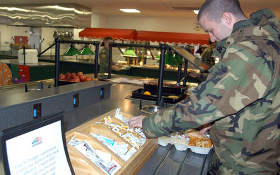 Airman 1st Class Noah Kelley, a Petroleum, Oil and Lubrication Systems airman at Misawa Air Base, Japan, grabs lunch to go Tuesday at Grissom Dining Facility. Takeout at both Grissom and the Falcon Feeder will be eliminated April 1 due to budget constraints.