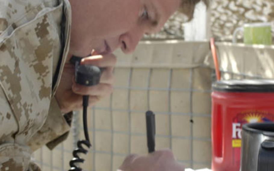 Cpl. James Wagner, 21, of Golden, Colo., records information for a fire mission call for artillery. Based on calculations other Marines make in the fire direction center, he records the deflection quadrant, amount of charge to be used, type of propellant, shell and fuse, and calls that out to Marines who then position the Howitzer and fire.