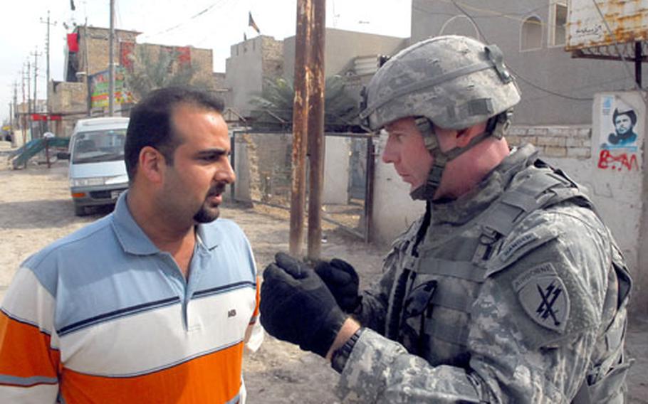 U.S. Army Capt. Bruce Beardsley, 38, of Germantown, Md., talks to an Iraqi man about the Mahdi Army militia?s return to eastern Baghdad. Beardsley, a civil affairs officer, had visited the neighborhood of Obaidy, where faded posters of radical cleric Moqtada Al Sadr studded the walls of houses and shops.