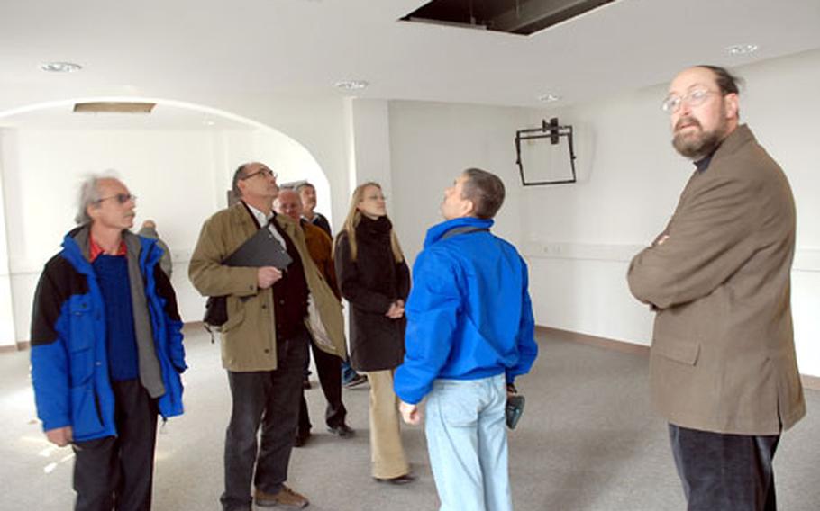 Representatives of the American military and the German government inspect what was once the Division Support Command&#39;s conference room on Harvey Barracks in Kitzingen, Germany. At right is Steve Donnelly, director of public works for the Würzburg military community.