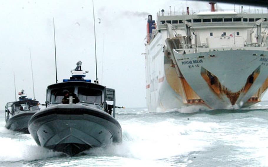 Dauntless Patrol Craft from Inshore Boat Units 11 and 13 pass a large ferry in Busan Harbor during a training exercise Tuesday.