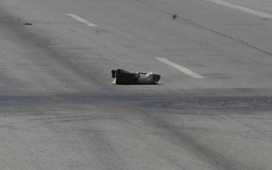 A muffler sits in the middle of a major highway east of Fallujah in a spot blackened by an earlier roadside bomb explosion. The roadway is notorious for roadside bombs and sniper attacks. Three Marines with Company B, Assault Amphibious Battalion, were killed in separate attacks on the road in December.