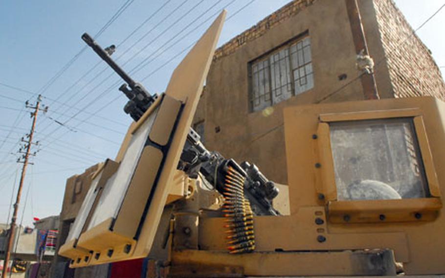 An Army machine gunner hunkers down in the turret of a Humvee while on patrol in East Baghdad recently, his helmet barely visible through the armored glass. Days earlier, a sniper had shot and killed another gunner in his platoon.