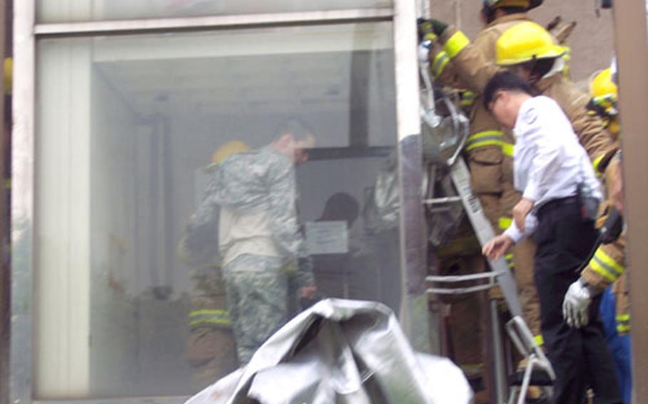 Yongsan Garrison firefighters remove Pfc. Jo H.S. from an elevator shaft after his head caught between the elevator and a metal support bar at Building S-1683, about a block from the “kimchi pot” gate at 1:45 p.m. Monday.