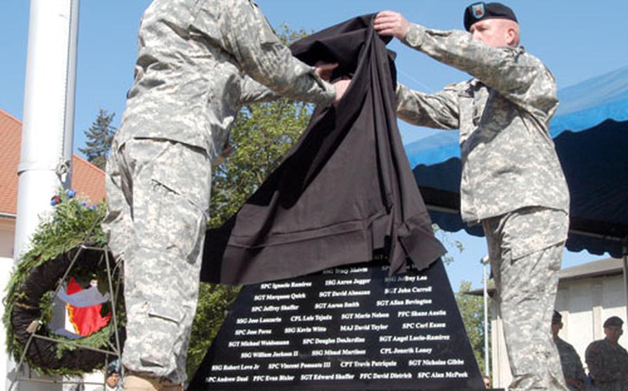 Maj. Gen. Fred D. Robinson Jr., left, and Command Sgt. Maj. Roger P. Blackwood unveil the memorial to fallen soldiers of the 1st Armored Division&#39;s 1st and 2nd Brigade Combat Teams, and 2nd Brigade Combat Team, 1st Infantry Division.