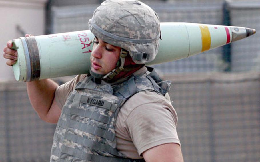 Spc. Joseph Nygard carries a 100-pound white phosphorous marking round, as Battery B, 4th Battalion, 25th Field Artillery, 10th Mountain Division, fires at anti-coalition positions in northeast Afghanistan.